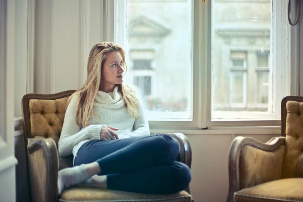 pexels-photo-761872-761872 A serene moment of a woman in a cozy room, enjoying leisure time by the window.